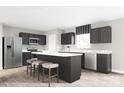 Modern kitchen with dark cabinets, stainless steel appliances, and a stylish island with seating at 12109 Beaux Art Ln, Charlotte, NC 28214