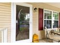 Welcoming front porch featuring a storm door, red shutters, exterior lighting, and comfortable seating, offering an inviting entrance at 122 Pratt St, Belmont, NC 28012