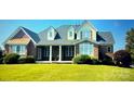 Inviting brick home featuring a well-manicured lawn, covered porch, and shuttered windows at 140 Hunters Hill Dr, Statesville, NC 28677