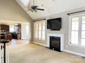 Comfortable living room showcasing a fireplace, large windows, and seamless flow to the kitchen at 140 Hunters Hill Dr, Statesville, NC 28677