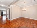 Spacious dining area with hardwood floors, elegant chandelier, and neutral wall paint, creating a welcoming atmosphere at 14700 Old Vermillion Dr, Huntersville, NC 28078