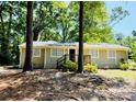 Classic single-story home with a quaint front porch nestled among mature trees at 1583 Green Circle Dr, Gastonia, NC 28054