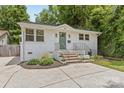 Charming white brick home with landscaped front yard, concrete driveway, and welcoming green front door at 1713 Shamrock Dr, Charlotte, NC 28205