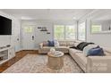 Inviting living room with a large sectional sofa, decorative rug, and plenty of natural light from multiple windows at 1713 Shamrock Dr, Charlotte, NC 28205