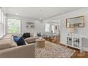 Bright living room featuring a comfortable sectional sofa, large area rug, and adjacent dining area with modern table at 1713 Shamrock Dr, Charlotte, NC 28205