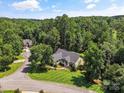 Scenic aerial view of house surrounded by lush trees, manicured lawn, and green landscape at 1819 Brompton Ct, Newton, NC 28658