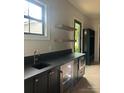 Stylish bar area featuring a wine fridge, dark countertops and floating shelves at 2412 Kingsbury Dr, Charlotte, NC 28205