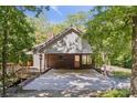 The rear of a brick home with a large concrete patio, wooden deck, and an exterior door at 3090 Goblet Rd, Richburg, SC 29729