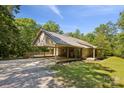 Charming brick home featuring a metal roof, covered carport and a spacious wooden deck surrounded by lush greenery at 3090 Goblet Rd, Richburg, SC 29729