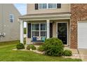 Inviting front porch with a bench seating area, attractive landscaping, and a welcoming front door with a wreath at 515 Benford Ln, Stanley, NC 28164