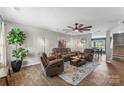 Bright living room featuring hardwood floors, modern decor, and an open layout connecting to the dining area at 515 Benford Ln, Stanley, NC 28164