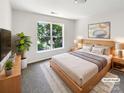 Bright bedroom with a large window, queen bed, stylish decor, and a hardwood frame at 6413 Fillian Ln, Charlotte, NC 28269
