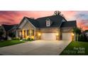 Charming brick home featuring a well-manicured lawn, inviting front porch, and a spacious three-car garage at 7026 Wyngate Pl, Lancaster, SC 29720