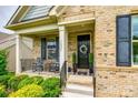 Inviting front porch with rocking chairs, manicured landscaping, and a welcoming front door with wreath at 7026 Wyngate Pl, Lancaster, SC 29720