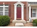 A close up of the front door with brick facade and classic white trim at 7943 Mariners Pointe Cir, Denver, NC 28037