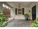Cozy front porch with brick siding, hanging light fixture, and a welcoming porch swing at 829 Sedgefield Rd, Charlotte, NC 28209