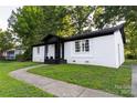 A charming white brick home featuring a well-kept lawn and a quaint front porch at 901 Echo Glen Rd, Charlotte, NC 28213