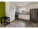 Well-lit kitchen with white cabinets, granite counters, and modern stainless steel appliances at 901 Echo Glen Rd, Charlotte, NC 28213