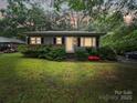 Charming single-story home at dusk, framed by mature trees providing ample shade and curb appeal at 1004 E 8Th Ave, Gastonia, NC 28054