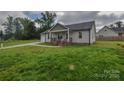 View of a charming single-story home with a well-manicured lawn, and an inviting front porch at 108 Devynne Ct, Salisbury, NC 28146