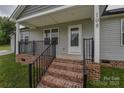 Inviting covered front porch with brick steps and black metal railings leading to the front door at 108 Devynne Ct, Salisbury, NC 28146