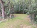 Serene backyard setting with mature trees and a grassy area, perfect for outdoor activities at 12 Watts St, York, SC 29745
