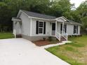 Well-maintained home featuring a concrete driveway, tidy landscaping, and a cozy front porch at 12 Watts St, York, SC 29745