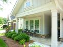 Inviting front porch with seating area and lush landscaping at 1311 Stonecroft Nw Ln, Concord, NC 28027