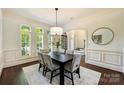 Bright dining room features large windows, hardwood floors, elegant wainscoting, and a stylish modern chandelier at 14652 Villalonga Ln, Charlotte, NC 28277
