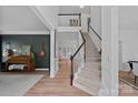 Elegant foyer featuring a staircase, dark accent wall, and wood flooring at 19746 Valiant Way, Cornelius, NC 28031