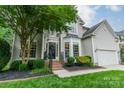 Beautifully landscaped front yard with a two-story home, black accents, and a well-maintained lawn at 211 Tyndale Ct, Waxhaw, NC 28173