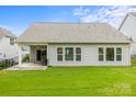 Rear exterior view of home showcasing a covered patio and large windows overlooking the backyard at 219 Broadleaf Dr, Denver, NC 28037