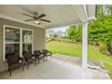 Inviting covered patio with a ceiling fan and comfortable seating overlooking the landscaped backyard at 219 Broadleaf Dr, Denver, NC 28037