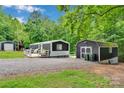 Charming home with a wooden deck and a gravel driveway surrounded by lush greenery and a storage shed at 2289 Mccloud St, Denver, NC 28037