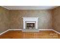 Cozy living room featuring a white fireplace with brick hearth and beautiful hardwood floors at 2605 Camelot Dr, Rock Hill, SC 29732