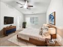 Staged bedroom with neutral walls, carpet, ceiling fan, and large window at 2618 Mt Holly Huntersville Rd, Charlotte, NC 28214