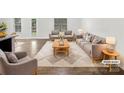 Bright, staged living room with neutral furniture, an area rug, and wood flooring at 2618 Mt Holly Huntersville Rd, Charlotte, NC 28214