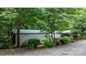 Exterior view of a home with a green roof, complemented by lush landscaping and a gravel driveway at 2951 Evergreen Trl, Vale, NC 28168