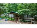Charming exterior of a home featuring stone accents, a wooden ramp, and lush landscaping at 2951 Evergreen Trl, Vale, NC 28168