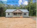 Eye-catching exterior of home featuring a cozy front porch, windows, and well-manicured lawn at 317 N Cemetery St, Richfield, NC 28137