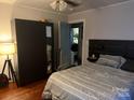 Cozy bedroom with modern decor featuring a bed with patterned linens and a storage cabinet at 3500 Blessing St, Charlotte, NC 28208