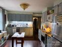 Well-lit kitchen with updated appliances, neutral cabinets, and a central work table at 3500 Blessing St, Charlotte, NC 28208