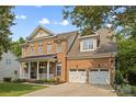 Charming brick home featuring a two-car garage, covered porch, well manicured lawn and basketball hoop at 362 Windell Dr # 67, Fort Mill, SC 29708
