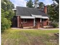 Quaint brick home with awnings over the porches, a chimney, and a grassy front yard at 3726 The Plaza None, Charlotte, NC 28205