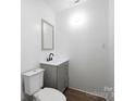 Contemporary bathroom featuring a toilet, gray vanity, modern sink, and a sleek mirror at 506 N Styers St, Cherryville, NC 28021