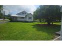The property features a spacious green lawn, mature trees and blue sky perfect for enjoying outdoor activities at 804 N Main St, Oakboro, NC 28129