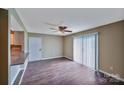 Open concept living room with wood-look floors and sliding glass doors to a patio at 809 High Meadow Ln # F, Charlotte, NC 28217