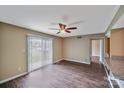 Bright living room boasts wood-look floors, ceiling fan, and sliding glass doors at 809 High Meadow Ln # F, Charlotte, NC 28217