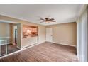 Living room includes wood-look floors, ceiling fan, and kitchen access at 809 High Meadow Ln # F, Charlotte, NC 28217
