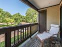 Relaxing outdoor balcony space with wooden floors, railings, and a comfortable chair at 8208 Cedar Glen Dr, Charlotte, NC 28212